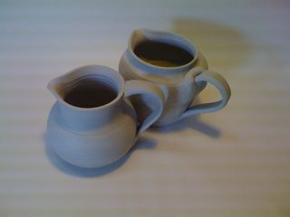 Greenware Two unfired ceramic pitchers with handles